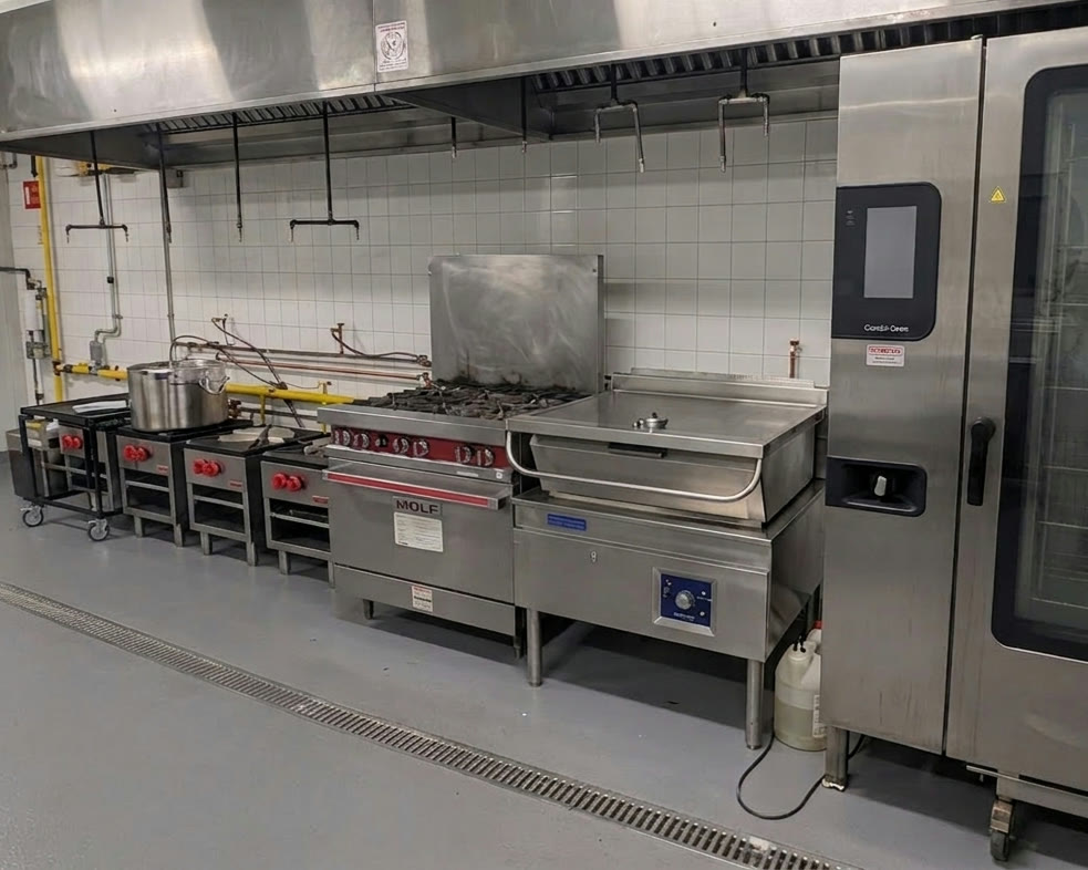 The full MiFoodStudio cook line running under a 20-foot stainless exhaust hood